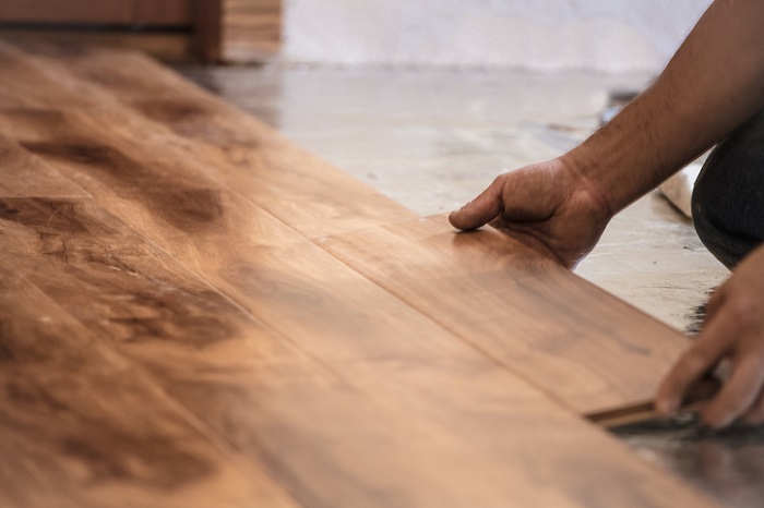 Mann verlegt Laminat mit Werkzeug