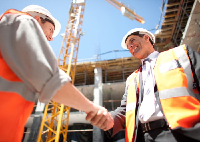 Zwei Bauarbeiter geben sich die Hand