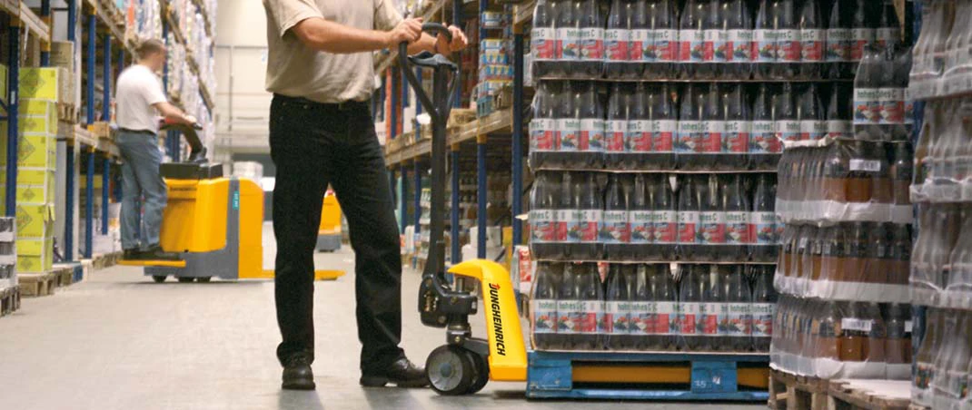 Mann befördert Getränke mithilfe eines Hubwagens