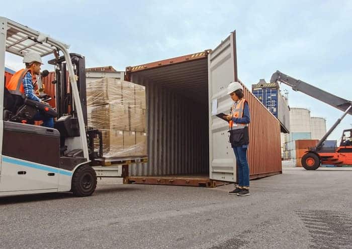 Paletten werden mit Flurförderzeug in Container verfahren