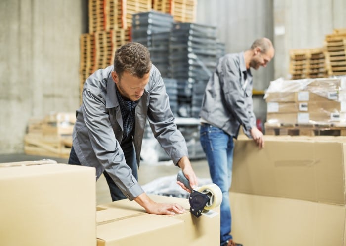 Zwei Männer mit Arbeitsmitteln im Lager