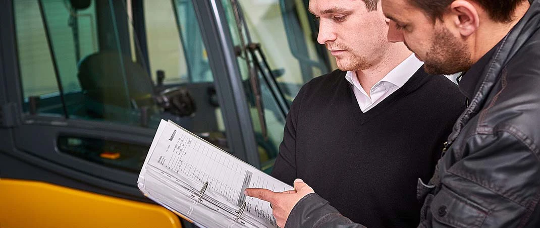 Zwei Männer führen die jährliche Unterweisung für den Gabelstapler durch