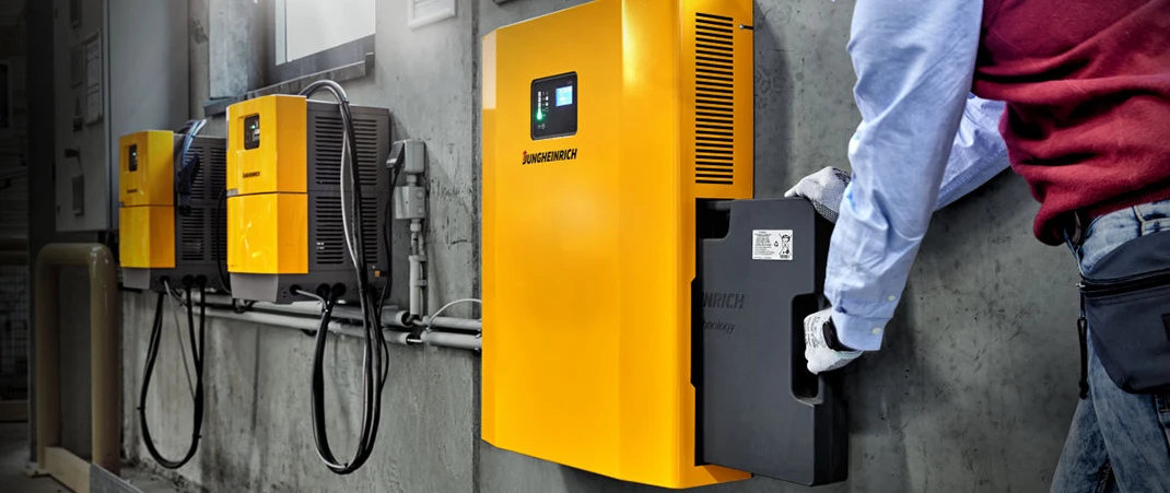 Mann lädt Lithium-Ionen-Batterie an Jungheinrich Batterieladegerät